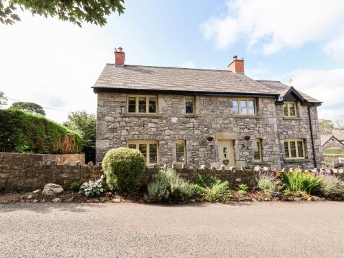 an old stone house with a gravel driveway at Garreg Wen in Holywell