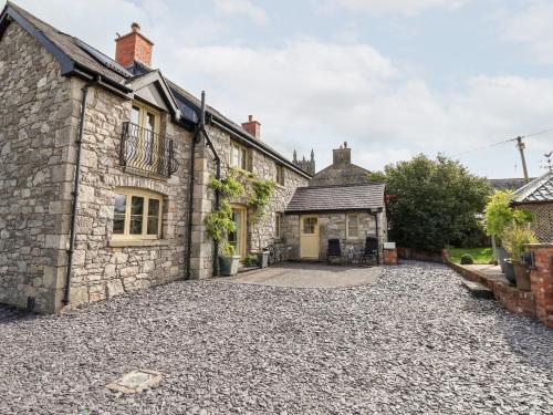 an old stone house with a gravel driveway at Garreg Wen in Holywell