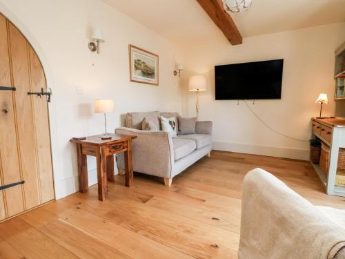 a living room with a couch and a tv at Garreg Wen in Holywell
