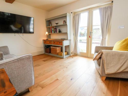 a living room with a couch and a tv on the wall at Garreg Wen in Holywell