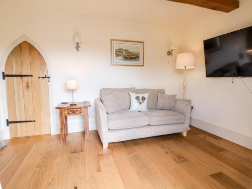 a living room with a couch and a tv at Garreg Wen in Holywell