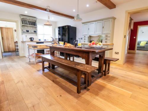 a kitchen with a wooden table with a bowl of fruit on it at Garreg Wen in Holywell