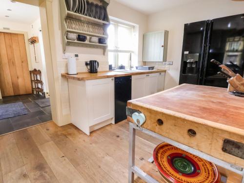 a kitchen with white cabinets and a black refrigerator at Garreg Wen in Holywell