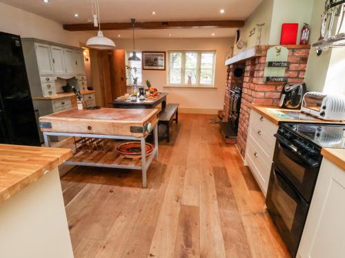 a kitchen with a wooden table in the middle at Garreg Wen in Holywell