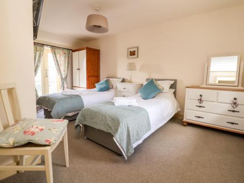 a bedroom with two beds and a dresser at Garreg Wen in Holywell