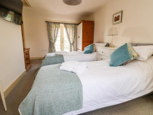 a bedroom with two beds and a window at Garreg Wen in Holywell