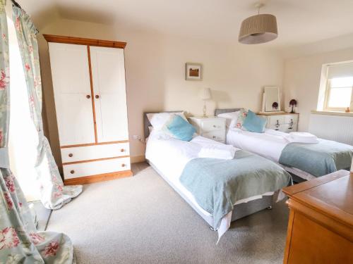 a bedroom with two beds and a dresser at Garreg Wen in Holywell