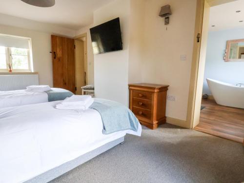 a bedroom with two beds and a tub and a sink at Garreg Wen in Holywell