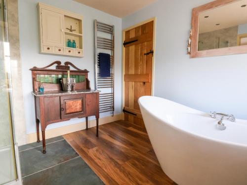 a bathroom with a tub and a sink at Garreg Wen in Holywell
