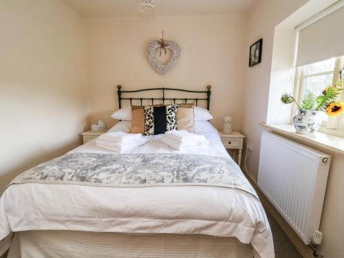 a bedroom with a bed with a heart wall hanging at Garreg Wen in Holywell