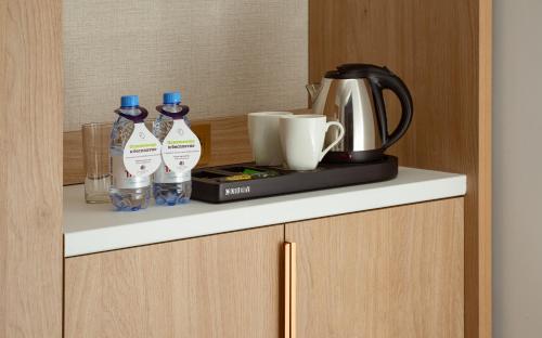 a shelf with bottles of water and a coffee maker at DoubleTree by Hilton Shymkent in Shymkent