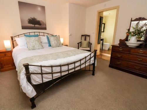 a bedroom with a large bed with a dresser and a dresser at Garreg Wen in Holywell