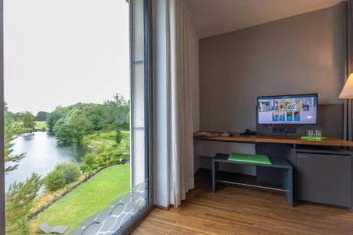 a room with a desk and a large window at LAGO hotel & restaurant am see in Ulm