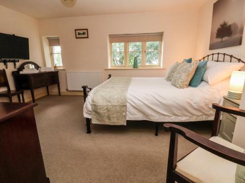 a bedroom with a bed and a desk and a television at Garreg Wen in Holywell