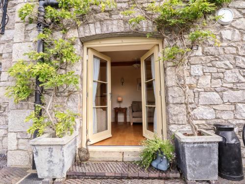a door to a stone building with potted plants at Garreg Wen in Holywell