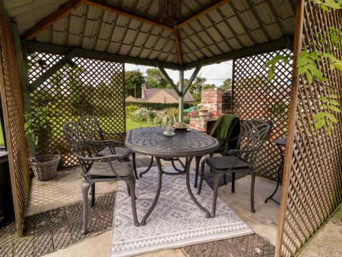 a gazebo with a table and chairs on a patio at Garreg Wen in Holywell