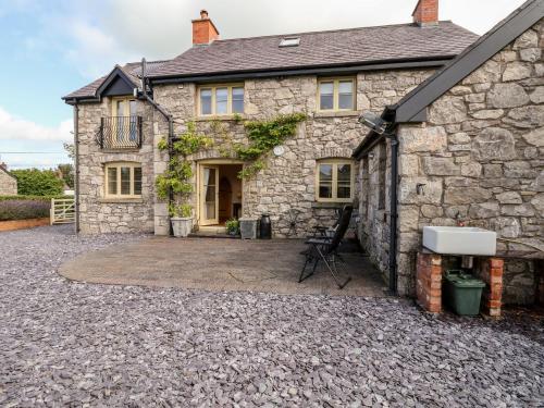 a stone house with a patio in front of it at Garreg Wen in Holywell
