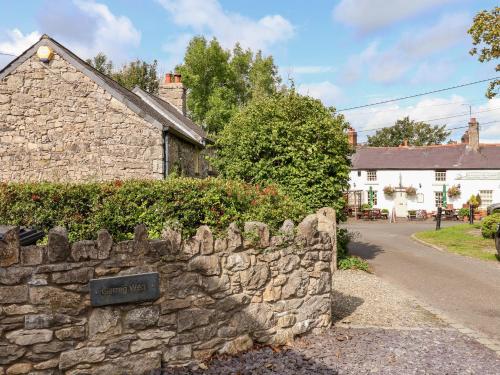 a stone wall in front of a house at Garreg Wen in Holywell