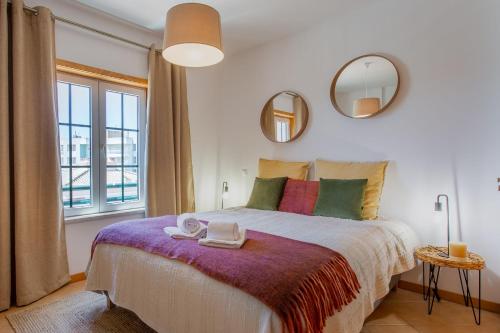 a bedroom with a large bed with two mirrors at Arcos d'Alvor in Alvor