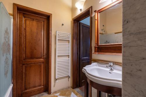 La salle de bains est pourvue d'un lavabo et d'un miroir. dans l'établissement Fattoria la Gigliola - Il Frantoio, à Montespertoli