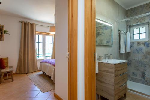 a bathroom with a shower and a sink and a bed at Arcos d'Alvor in Alvor