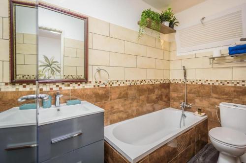 a bathroom with a tub and a toilet and a sink at 1A - Chambres et Appartements au calme - Centre St Denis - Barachois in Saint-Denis