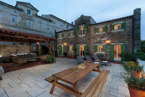 a patio with a wooden table in front of a building at Casa Histria in Motovun