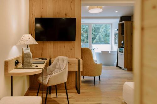 a living room with a desk and a kitchen with a television at Hotel Klosterbräu in Seefeld in Tirol
