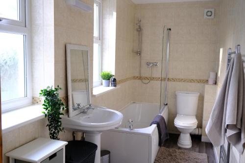 uma casa de banho com um lavatório, uma banheira e um WC. em Beautiful Cottage with Sea Views Cornwall em Saltash