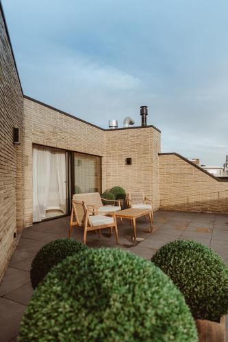 a patio with two chairs and a table on a building at CH Longstay 2 in Kortrijk