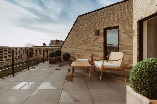 a patio with chairs and a table on a brick wall at CH Longstay 2 in Kortrijk