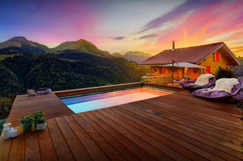 a pool on a deck with a view of mountains at Chalet Manoe - OVO Network in Manigod