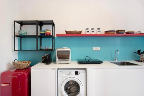 a kitchen with a washing machine and a sink at Il ciliegio di Miki in Genova