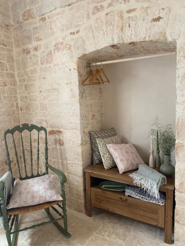 a chair sitting next to a table with pillows at La Casetta in Alberobello