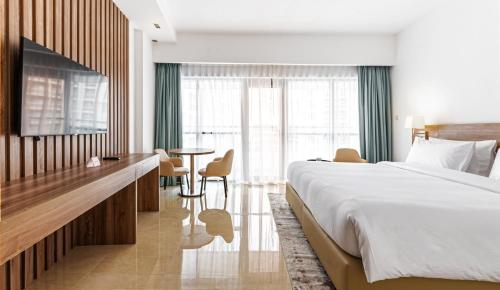 杜拜的住宿－Pyramisa Hotel Apartments，酒店客房设有一张大床和一张桌子。