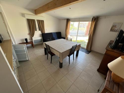 a dining room with a table and chairs and a couch at Chambre d'hôte Les Murailles in Auterive
