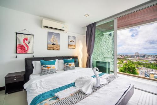 Patong Villa1三卧泳池别墅两个海景房 近班赞江西冷海滩中文管家 في شاطيء باتونغ: غرفة نوم بها سرير ونافذة كبيرة