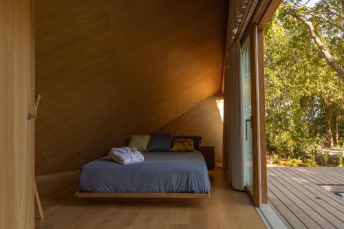 Cabañas de Xarás, Mimosa في مارين: سرير في غرفة صغيرة مع شرفة