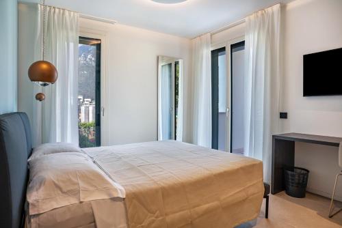 a bedroom with a bed and a large window at Appartamento Midum Garden Nord in Trento