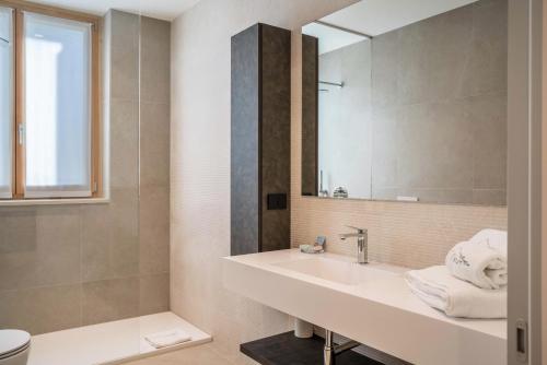 La salle de bains est pourvue d'un lavabo et d'un miroir. dans l'établissement Appartamento Midum Family Balcony, à Trente
