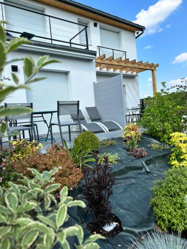 eine Terrasse mit Stühlen und Pflanzen vor einem Haus in der Unterkunft La villa perchée in Saint-Prix