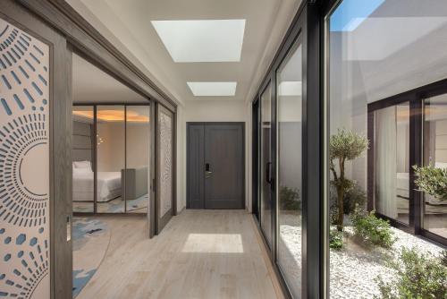 a hallway with glass doors and a bed in the distance at The Westin Dragonara Resort, Malta in St. Julianʼs