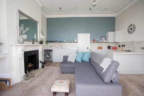 a living room with a couch and a kitchen at Seaways Apartment in Worthing