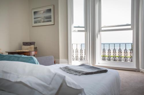 a bedroom with a bed and a large window at Seaways Apartment in Worthing