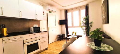a kitchen with a table and a dining room at Oshun Plaza Castilla in Madrid