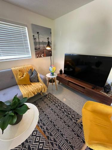 een woonkamer met een grote flatscreen-tv bij Cozy & Confy apt w/full kitchen for 4ppl in Fort Lauderdale