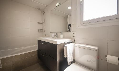 a bathroom with a sink and a toilet and a mirror at TH46 Casa con piscina 900 m de la playa Arrebassada in Tarragona