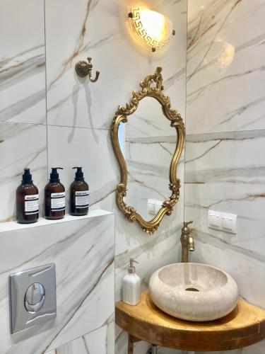 a bathroom with a gold mirror and a sink at Villa Ulyana Sarti - Ancient Greece in Center in Sarti