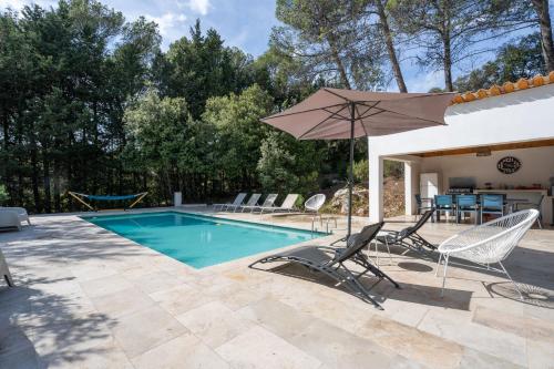 a swimming pool with chairs and an umbrella at La Bastide Blanche Magnifique villa 5 étoiles 5 chambres et piscine privée sur 6500 m VAR in Lorgues