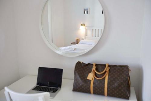 a laptop computer sitting on a desk with a mirror at Hotel Elite in Cervia